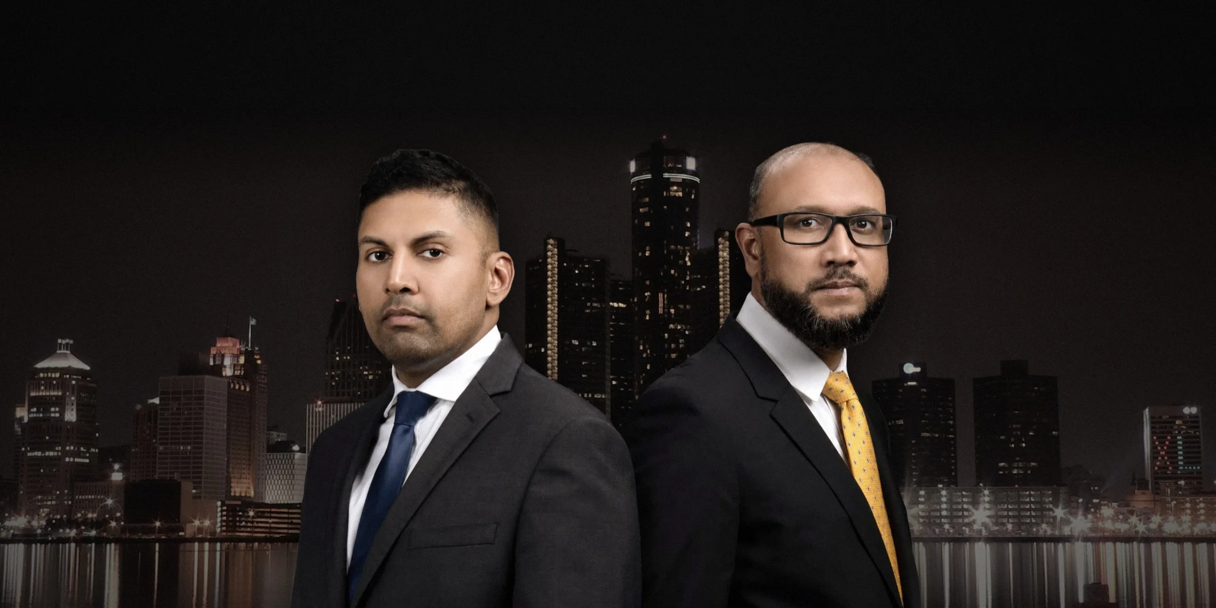 Attorneys Abe Barlaskar and Ruhul Mumen with the Detroit skyline